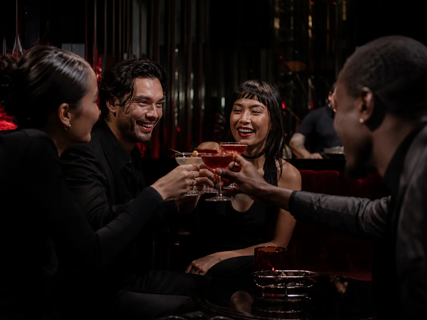 Guests raising cocktails in an intimate bar