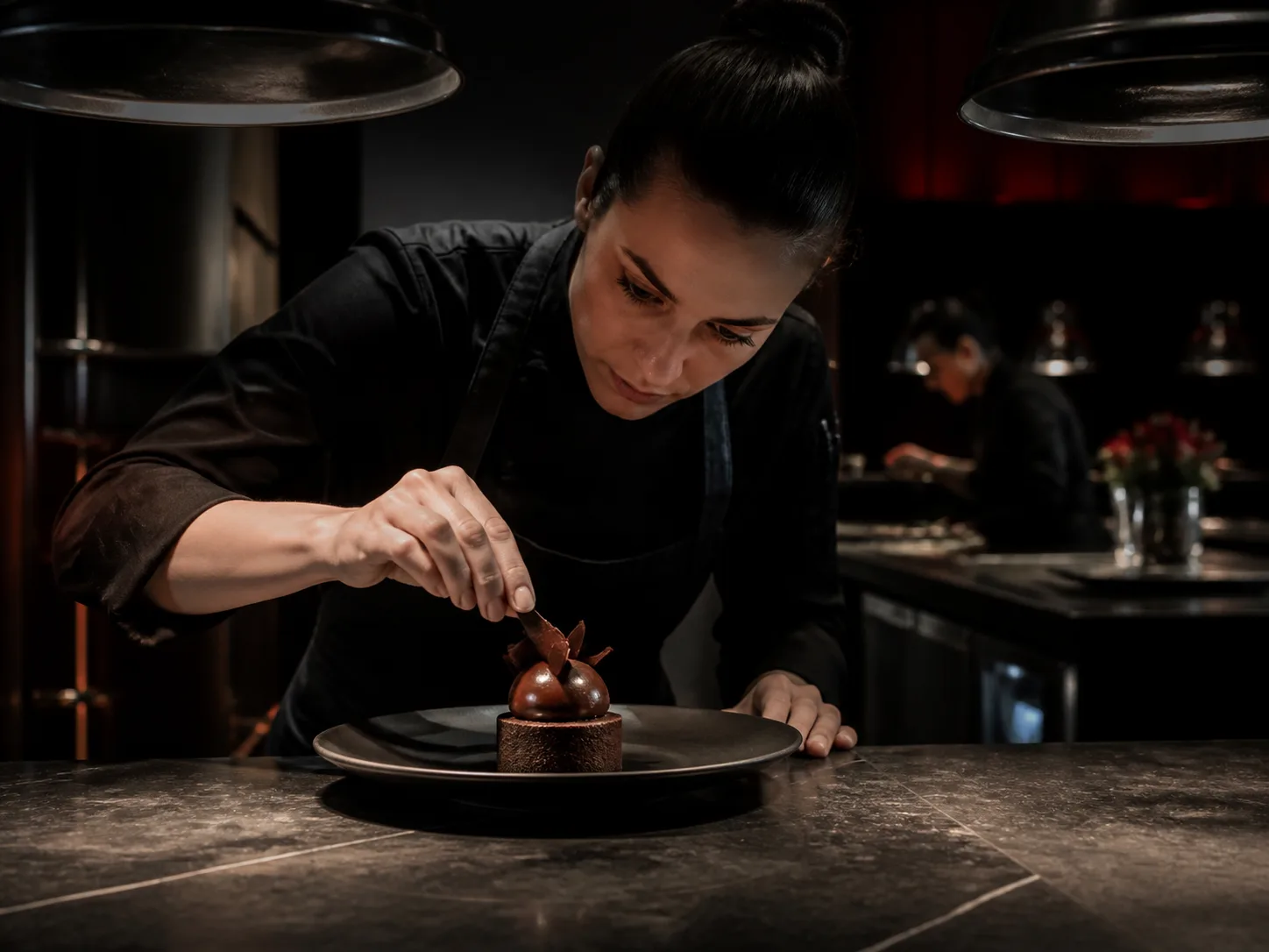 Pastry chef finishing a chocolate dessert